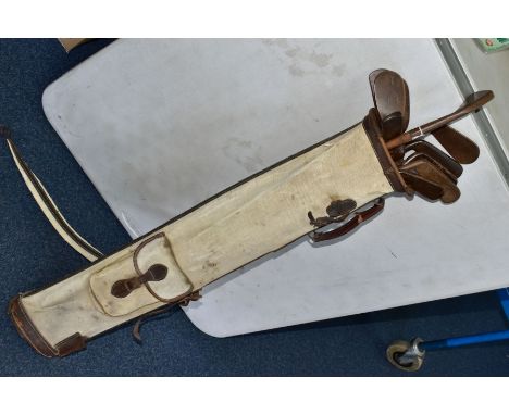 A VINTAGE CANVAS AND LEATHER TRIMMED GOLF BAG CONTAINING ELEVEN WOODEN SHAFTED GOLF CLUBS, brands include Arthur Claire, A. G
