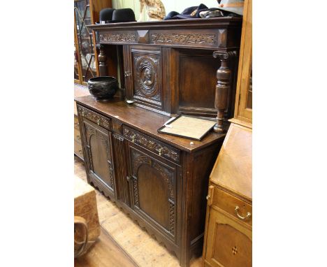 Early 20th Century carved oak court cupboard having turned pillars and portrait panel door above two drawers with two doors b