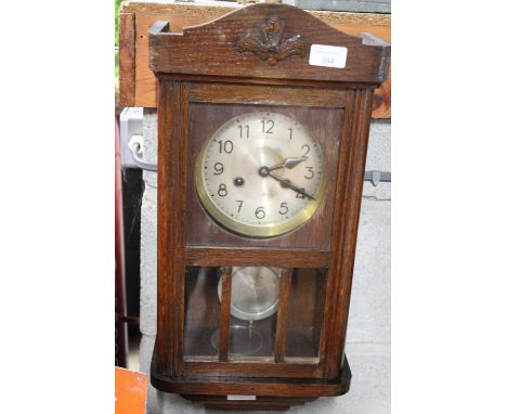 A vintage oak cased wall clock, with key 