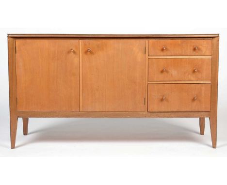 Storys, London; a mid-Century walnut sideboard, rectangular top with a channelled edge above cupboards doors with a shelf to 