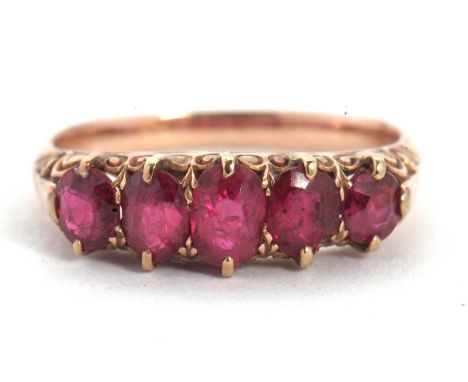 A five stone ruby ring, the five graduated rubies all claw mounted with a scrolled gallery and shoulders, plain band of unmar