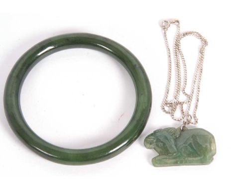 A jade bangle and pendant, the bangle with inner diameter 66mm wide, together with a pendant carved with a bull, 4cm wide, wi