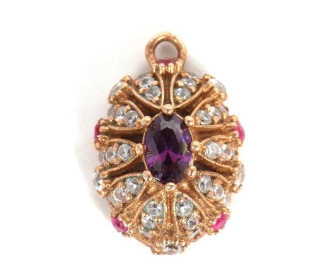 An amethyst, ruby and white stone pendant, the central oval amethyst surrounded by white stones with small ruby highlights, a