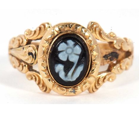 An early 19th century memorial ring, set to centre with an oval carved agate flower, with repousse surround and split repouss