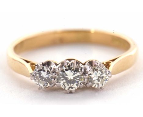 A three stone diamond ring, the three round brilliant cut diamonds, estimated approx. 0.42cts, all claw mounted to a plain ba
