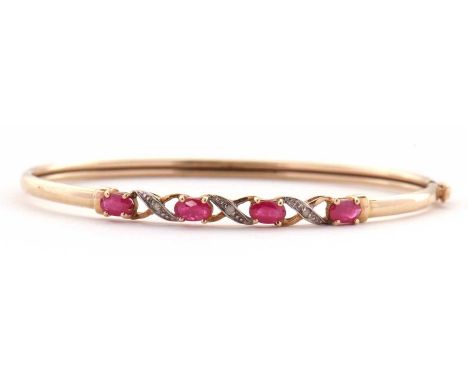 A 9k ruby and diamond bangle, the upper section set with four oval rubies interspaced with a cross of 9k gold and set with si