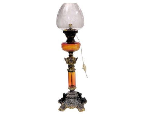 A late 19thC Young's metal and glass oil lamp, converted to electricity, the lamp with a brass capital, and fluted red to ora