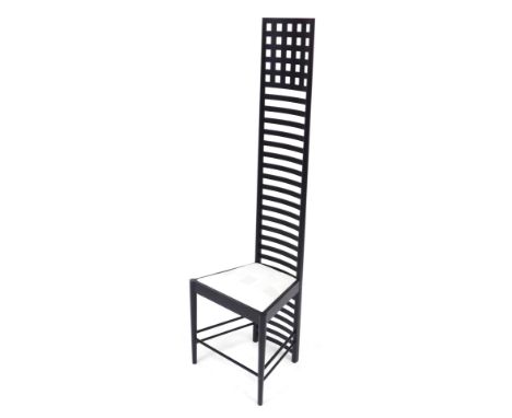 A Charles Rennie Mackintosh style ebonised ladder back chair, with a drop in seat, raised on turned legs united by stretchers