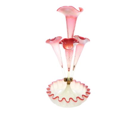 A Victorian opaline and cranberry glass four branch epergne, raised on a frilled base, 43.5cm high.