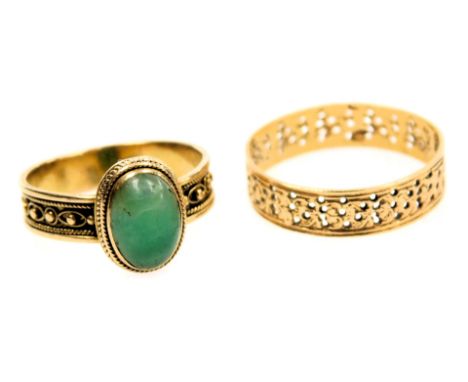 A continental yellow metal wedding band, with pierced decoration, size P, 1.5g, together with a green cabochon set ring, size
