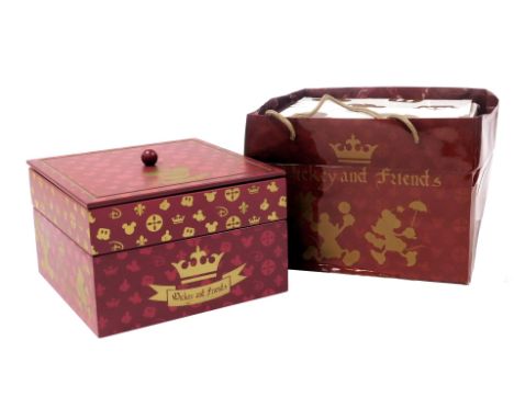 A Disney Mickey and Friends box, containing four porcelain cups, saucers and lids, decorated in gilt and pale brown with Disn