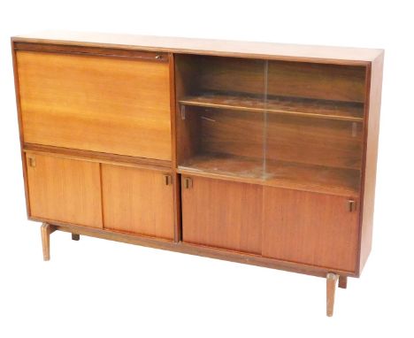 A mid century teak lounge unit, with a drop flap secretaire, flanked by two glazed doors enclosing a single shelf, above two 