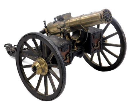 A brass and black metal scale model of a Gatling 1883 cannon, 36cm wide.