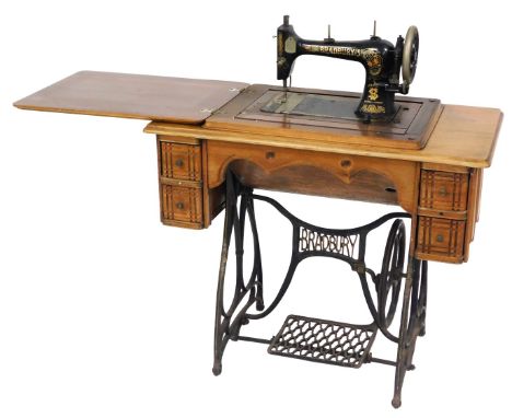 An early 20thC Bradbury's cast iron and oak treadle sewing machine, the machine, model Z16319, on a table base, with four fri