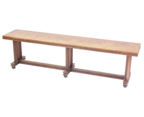 A Victorian oak bench, purportedly from the House of Lords, raised on carved supports, united by a double H stretcher, on bun