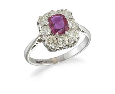 A RUBY AND DIAMOND CLUSTER RING an oval-cut ruby within a border of round brilliant-cut diamonds. Estimated total diamond wei