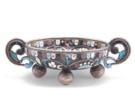 A RUSSIAN ENAMELLED TWO-HANDLED MINIATURE BOWL unmarked, of shallow form with scroll handles and raised on four bun feet, pic