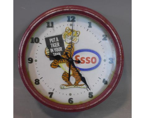 A vintage Esso wall clock, with tiger holding sign 'Put a Tiger in your Tank', the dial with Arabic numerals, battery operate