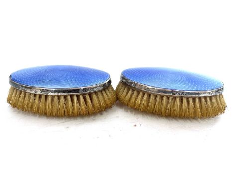 A pair of George VI silver and enamel clothes brushes of oval form having light blue guilloche enamel panels, hallmarked Birm