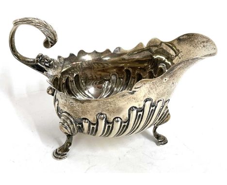 Victorian silver cream jug having a part fluted body, carved cut rim and a flying leaf capped handle supported on three hoof 