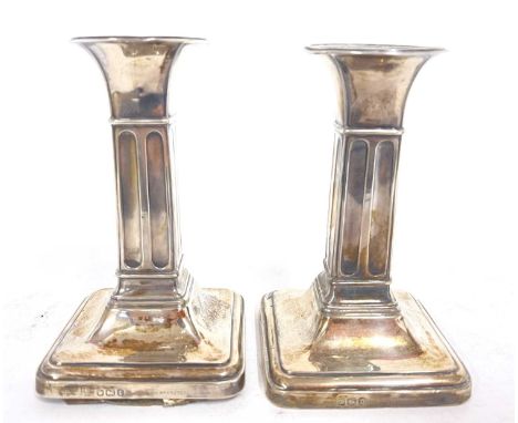 Small pair of Edwardian silver candlesticks having round capitals and square fluted colums to a loaded stepped base, hallmark