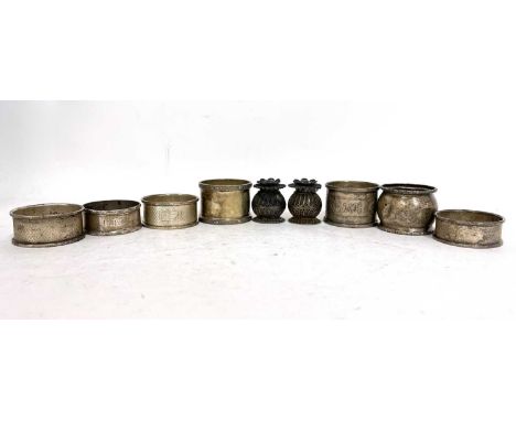 Mixed lot to include seven hallmarked silver serviette rings, various dates and makers together with a small pair of white me