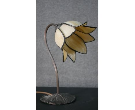 A Tiffany style stained glass desk lamp, the shade of flowerhead form, on a curved stem with a foliate base. H.36cm 