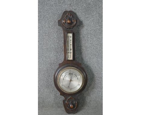 A late 19th century carved oak cased barometer with silvered dial. H.72 W.24cm 