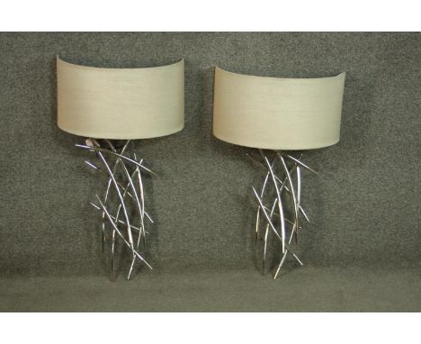 A pair of nickel plated abstract design wall lights by R.V.A. Lighting with cream semicircular shades. H.60 W 30cm. 