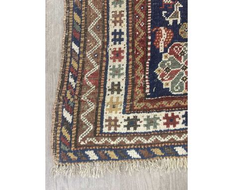 CAUCASIAN BORDERED RUG, decorated with three central lozenge shaped medallions, on a blue ground217cm x 126cmCondition good t
