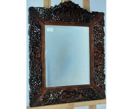 CHINESE HARDWOOD MIRROR, LATE 19TH/EARLY 20TH CENTURY the frame carved with flowers, figures, birds foliage and a village sce