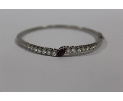 A BOXED LADIES WHITE METAL BANGLE SET WITH A CENTRAL MARQUIS CUT RUBY AND FOURTEEN PRINCESS CUT DIAMONDS  