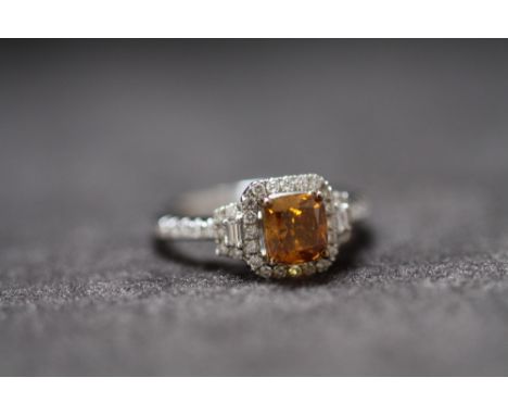 AN 18ct WHITE GOLD FANCY BROWN CUSHION CUT DIAMOND RING, with diamond halo and shoulders. Fancy diamond 1.06ct. RBC and bague