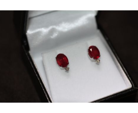 A PAIR OF 18ct WHITE GOLD RUBY AND DIAMOND STUDS, boxed. Rubies 4.00ct. Diamonds 0.06ct