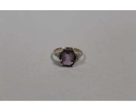 A VINTAGE 9CT GOLD AND SILVER DRESS RING SET WITH A PURPLE STONE 