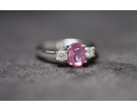 AN 18ct WHITE GOLD PINK SAPPHIRE AND DIAMOND THREE STONE RING, Oval-cut pink sapphire 1.50ct. RBC diamonds 0.35ct, Ring size 