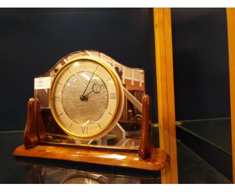 A Smiths mantle clock set in an amber mirror and bakelite stand