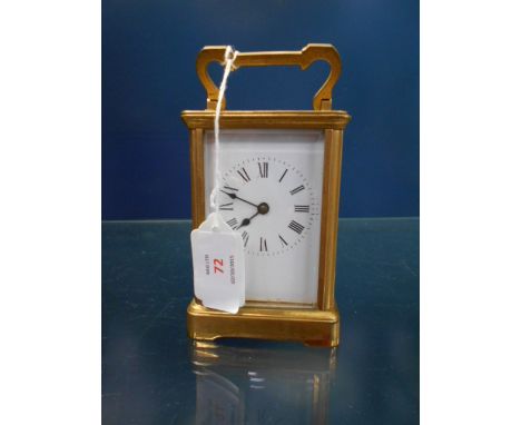 A brass and glass carriage clock with enamel dial and Roman numerals
