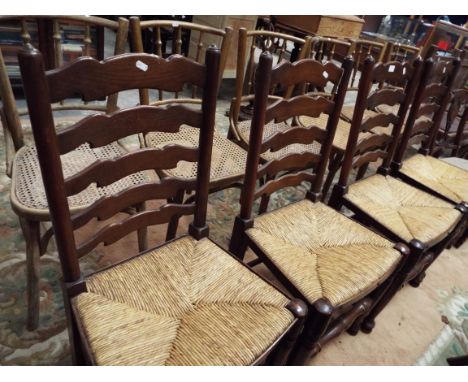 A set of four 20th C elm ladder back dining chairs with rush upholstered seat and raised on turned pole and pad supports