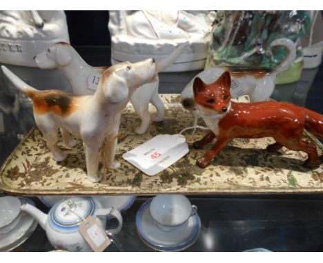 A Beswick fox with black tipped tail together with three hunting hounds