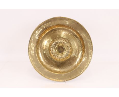 A 16th Century Nuremberg brass Alms dish with a central boss encircled by a ring of gothic script, 51cm dia.
