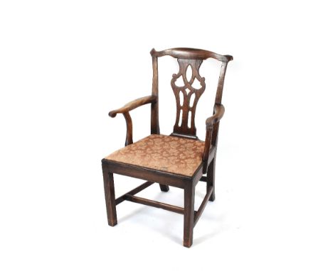 A George III elm Chippendale style elbow chair, having pierced splat back, upholstered lift out seat, raised on square taperi