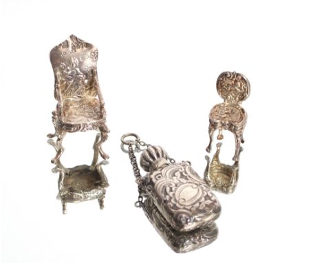 An antique miniature silver continental elbow chair bearing import marks, a similar miniature hall chair with cherub decorati