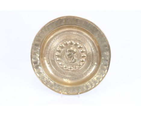A 16th century Nuremberg brass Alms dish with a central boss of a Roman Emperor encircled by a ring of gothic script, 39cm di