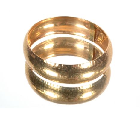 A yellow metal bangle marked 10K, approx. 8gms