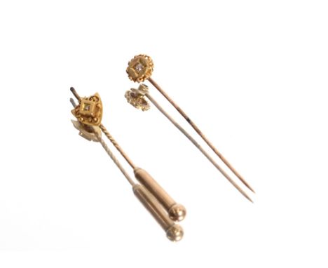 A yellow metal and diamond set stick pin, approximately 1gm, 5cm and a yellow metal stick pin, having 15ct gold shield shaped