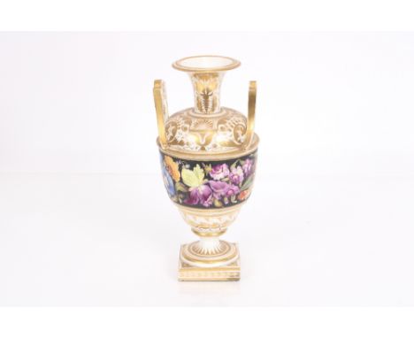 A large 19th century Coalport type baluster urn having foliate spray decoration heightened in gilt, flanked by loop handles, 