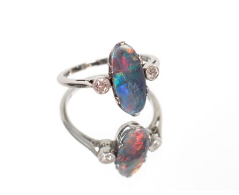 An 18ct white gold opal (possible doublet) and diamond set ring, the opal approx. 14mm x 6mm, each diamond approx. 3mm diamet