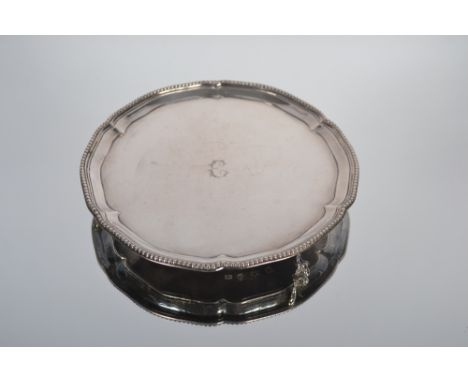 A George III silver card tray, with beaded pie crust border, initialled E to the centre; raised on ball and claw supports.  M