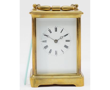 A brass striking carriage clock,  dial, striking the half and hours on a bell, 14cm.Not working, base has been bent, side gla